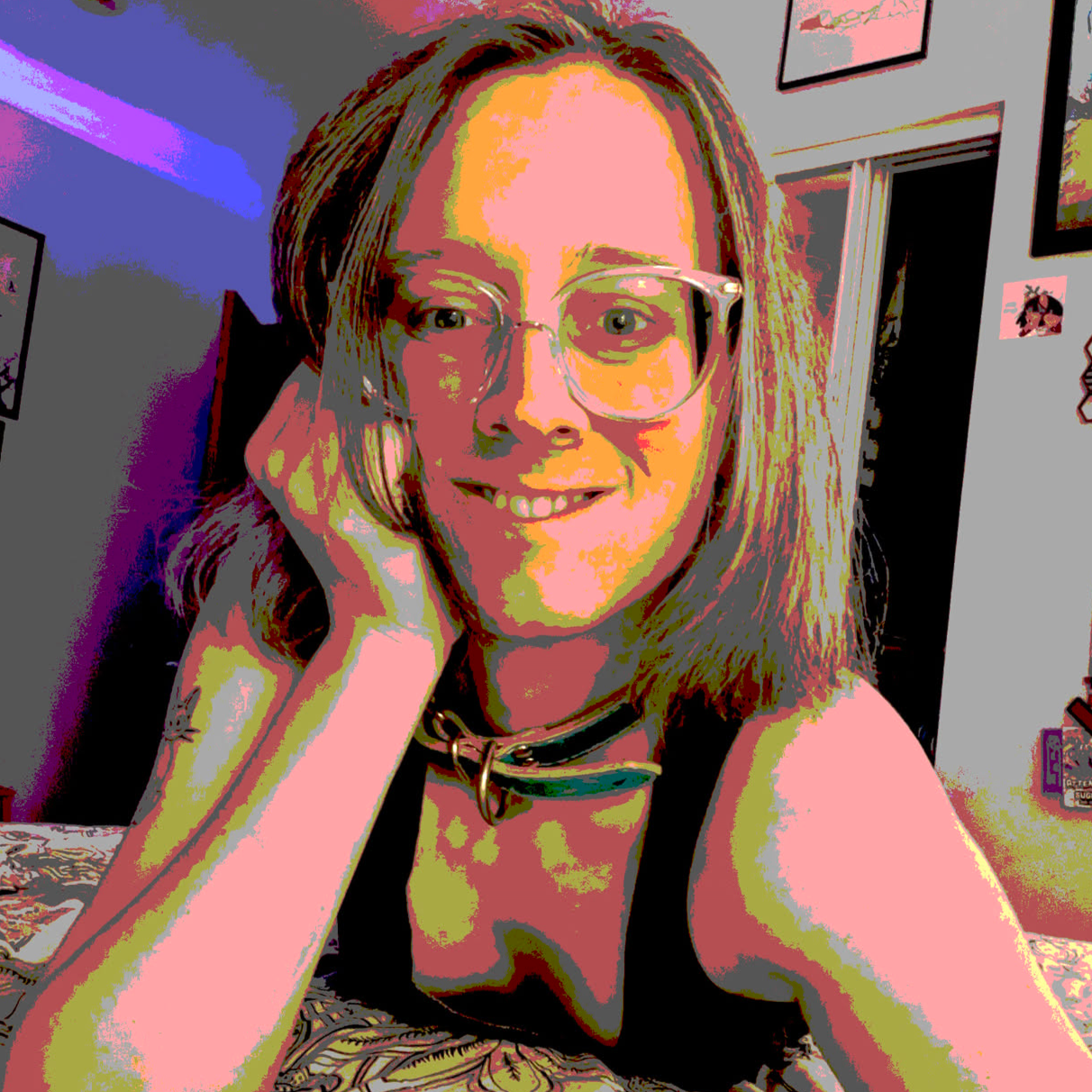 heavily posterized selfie of Liz Sugar in her new collar and a low cut top.  Posterized means that the photo colors have been simplified into bands of separate colors that would be easier to print on a poster.  The selfie is taken from the front and she is laying on her front with her head propped on her hand.  this is raising her shoulders to let you see into her cleavage through her low cut top.  the posterization makes the lighting extra stark here.  she is wearing a green collar around her neck and smiling while biting her lower lip.  her eyes are smiling too